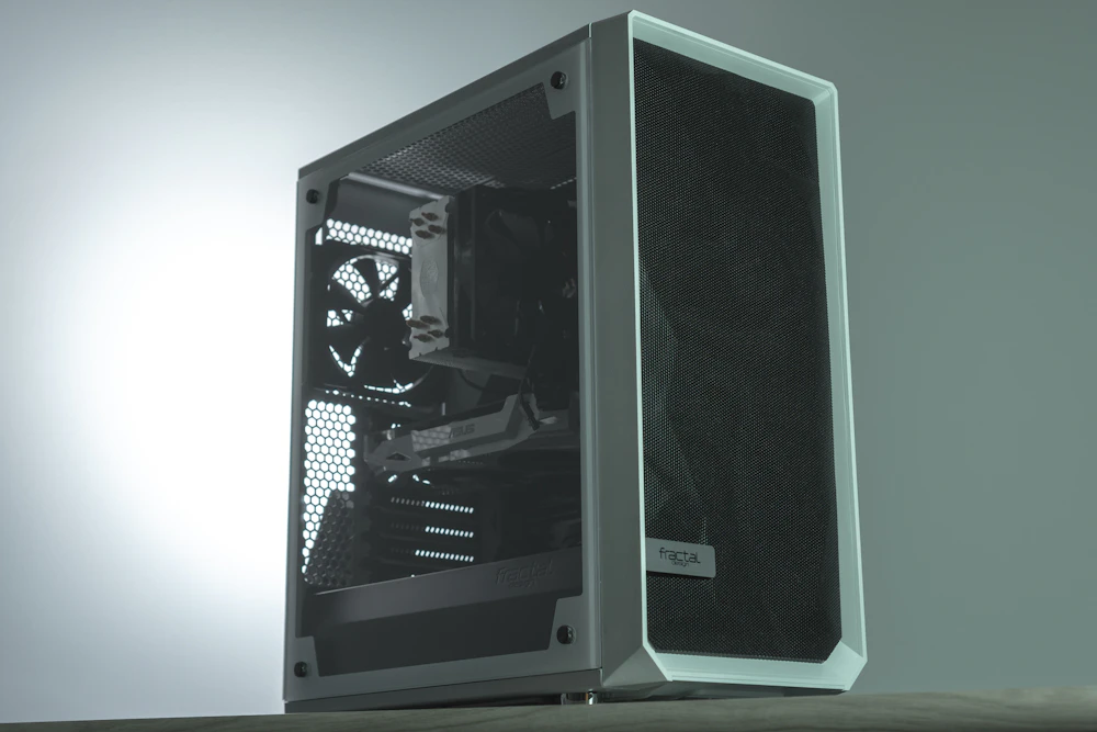 Fotografia de um gabinete preto com lateral de vidro e frente ventilada, em ambiente com iluminação natural